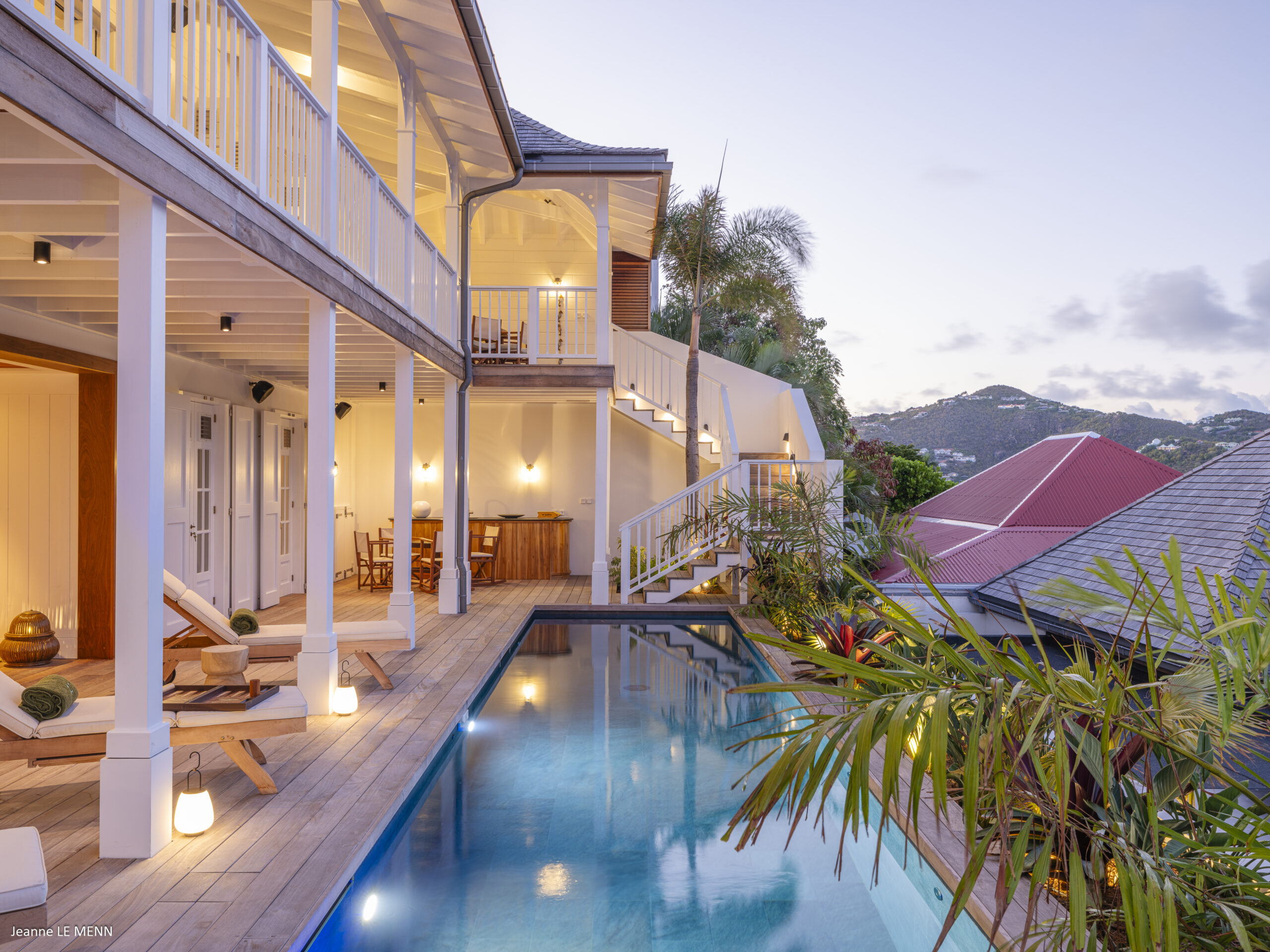 Infinity pool overlooking a beautiful view at sunset, with warm colors reflecting on the water.