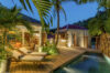 Evening pool terrace with glowing lights, palm trees, and sun loungers at a luxury St Barts villa rental.