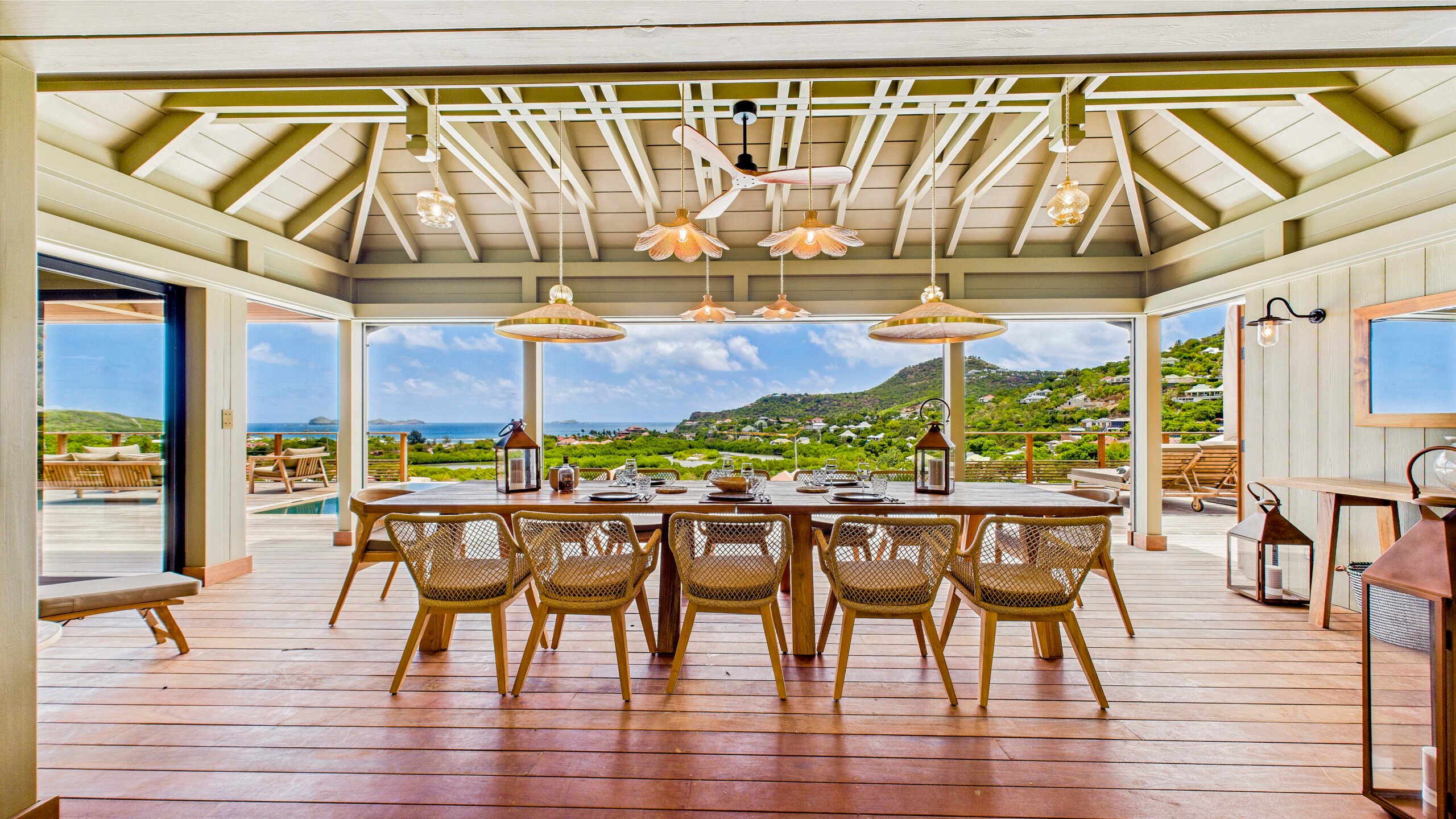 Luxury villa pool terrace in St Barts with loungers overlooking turquoise waters.