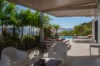 Covered villa terrace with lounge chairs and tropical plants overlooking private pool and Gustavia harbor in St Barts luxury rental