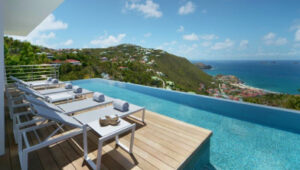 Infinity pool at Villa 3H with panoramic views of the Caribbean Sea and island hills.