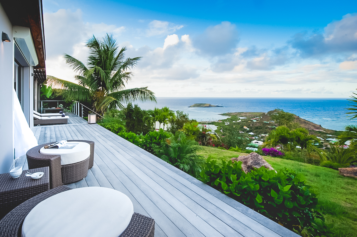 Terrace with lounge chairs overlooking Caribbean Sea and hillside at St Barthelemy vacation rental.