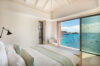 Serene bedroom in St Barts villa with floor-to-ceiling window overlooking Gustavia harbor