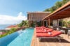 Infinity pool with red loungers at luxury St Barts villa rental overlooking the Caribbean Sea