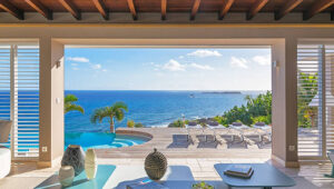 Modern villa with infinity pool overlooking the ocean at sunset in St. Barts.