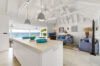 Modern kitchen island with ocean view and open living room at St Barts luxury villa rental.