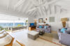 Bright living room with vaulted ceiling and terrace overlooking ocean at St Barthelemy villa rental.