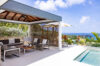 Covered outdoor lounge beside infinity pool with ocean views at a luxury St Barts villa rental