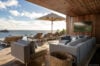 Ocean-view terrace of a luxury St Barts villa with shaded lounge seating, sunbeds, infinity pool, and panoramic Caribbean sea views