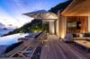 Luxury St Barts villa terrace at sunset with infinity pool, sun loungers, modern lounge area, and ocean views