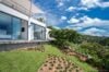 Contemporary St Barts villa with landscaped garden, floor-to-ceiling windows, and hillside island views.
