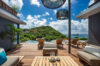 Luxury villa terrace with sun loungers, modern lounge seating, and infinity pool overlooking lush hills and ocean in St Barts rental