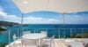 Terrace dining area at St Barts villa overlooking turquoise sea and coastal hills.