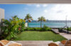 Seaside garden at luxury villa st barths with palm trees, sailboats, and Caribbean horizon views.