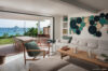 Open-plan living room at St Barts villa rental with modern art wall, natural wood furniture, and ocean-view terrasse dining