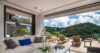 Luxury villa living room with white sofa and orchids opening to terrace with sun loungers and hillside views in St Barts rental