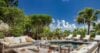 Outdoor lounge and pool at St Barts villa surrounded by palm trees.
