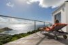Guest relaxing on sun lounger with panoramic ocean view from terrace at St Barts villa rental