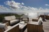 Outdoor terrace lounge with wooden furniture and panoramic sea view at St Barthelemy vacation rental.