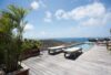 Deck with sun loungers beside narrow pool overlooking ocean at St Barts private villa rental.