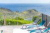 Terrace with sun loungers overlooking St Barts hills and ocean.