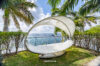 Seaside villa garden with modern canopy daybed and panoramic Caribbean views in St Barts luxury vacation rental