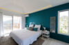 Bedroom with teal accent wall, king bed, and terrace access at St Barts villa rental.
