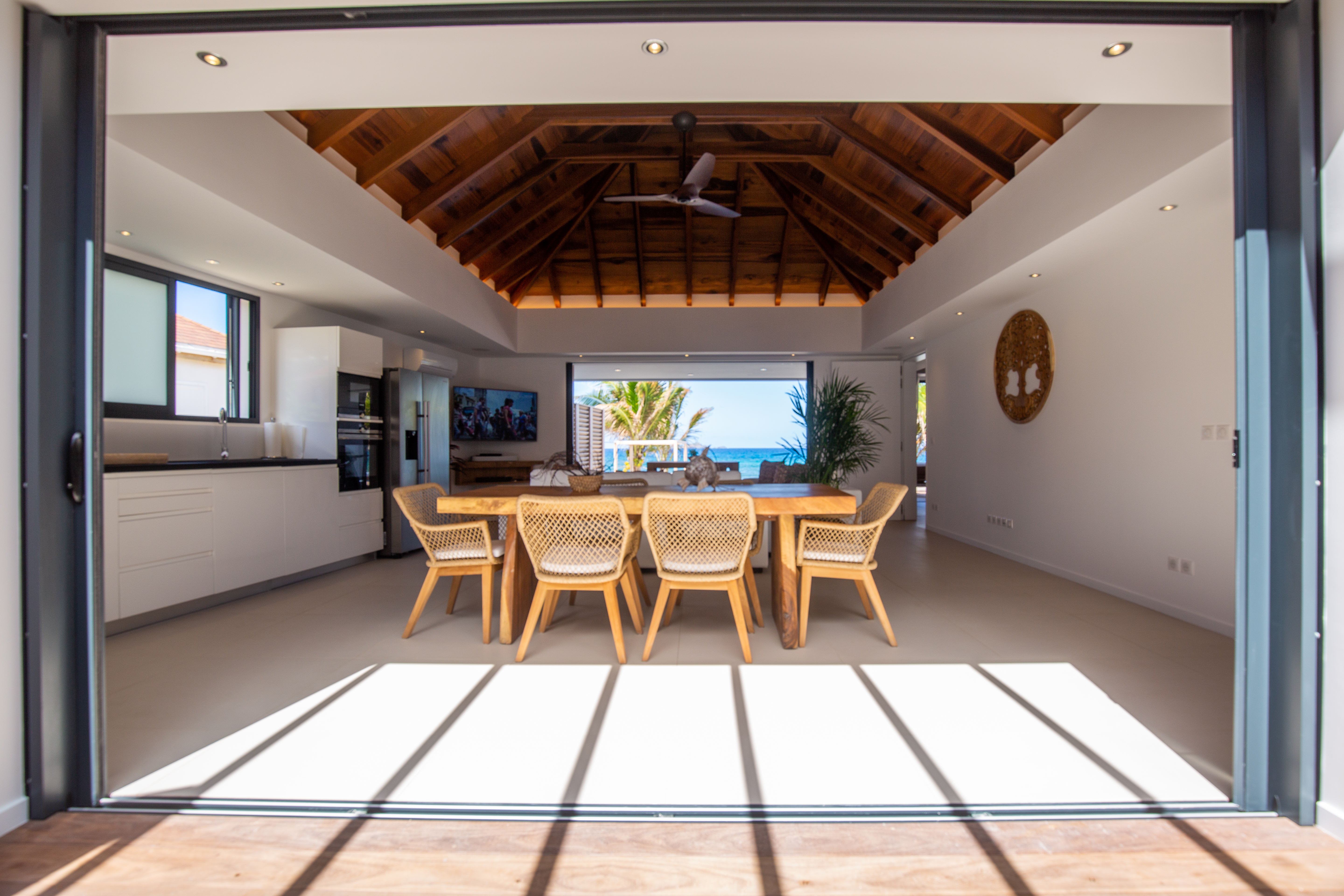 Open-air dining room with ocean view and wooden ceiling inside beachfront villa rental in St Barthélemy