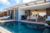 Modern open-air villa in St Barts with private pool, sun loungers, and shaded dining terrace surrounded by tropical wood accents.