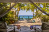 Private villa rentals in st barts with oceanfront deck framed by palm trees and lounge chairs.