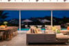 Open-plan living and dining area overlooking the illuminated pool and hillside lights at a St Barts luxury villa rental
