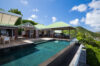 Infinity pool at luxury st barts villa with hillside view and open-air living spaces.
