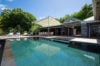 Private pool at luxury st barts villa surrounded by tropical greenery and open-air dining area.
