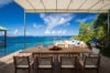 Outdoor dining terrace at luxury st barts villa with panoramic ocean view and clear blue sky.