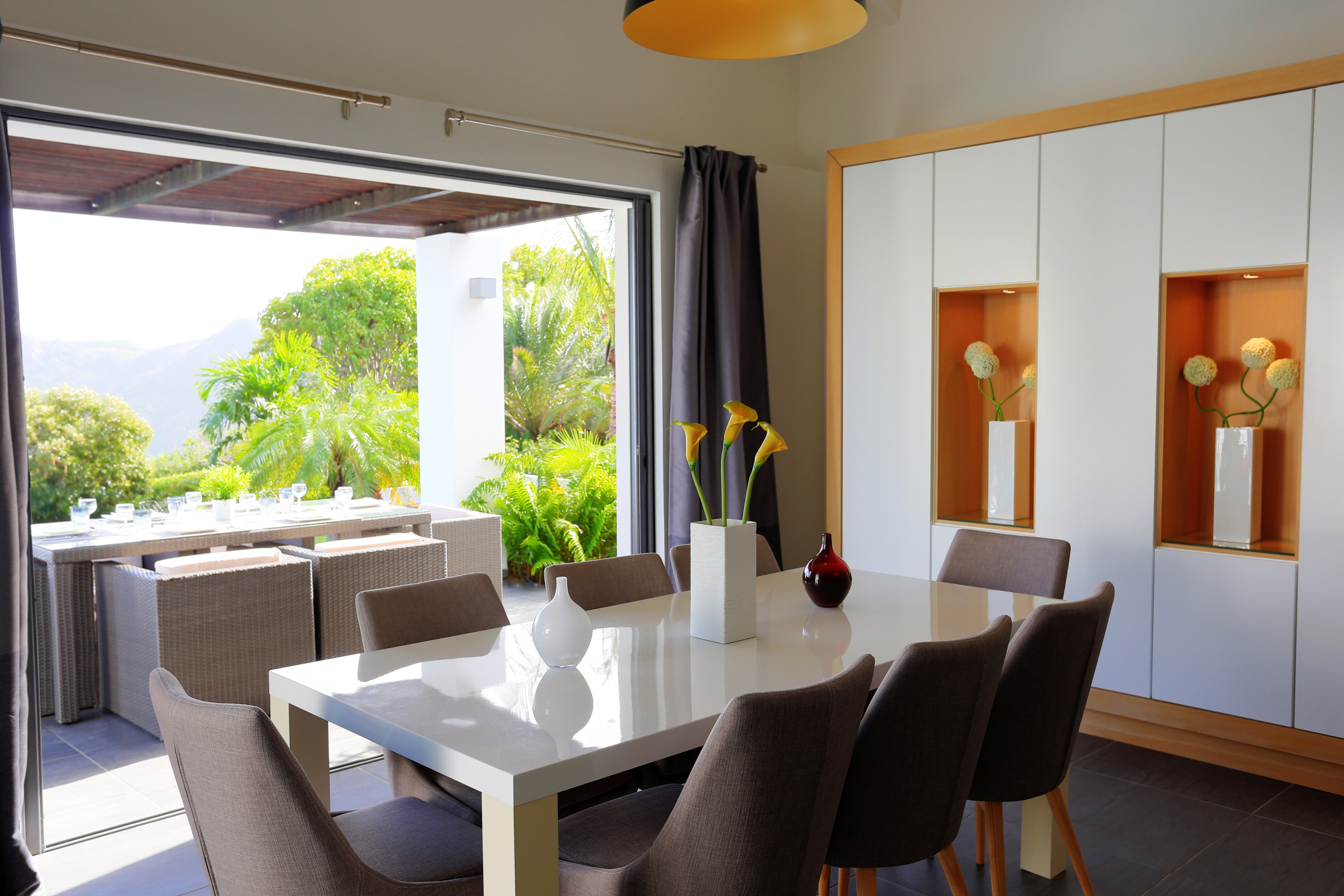 Bright dining room with modern furniture and open terrace view at a luxury villa rental in St Barts