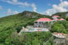 Aerial view of hillside luxury villa with red roof, infinity pool, and panoramic ocean view in St Barthélemy