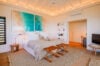 Spacious bedroom with coastal artwork, vaulted ceiling, and neutral tones at a luxury villa rental in St Barts
