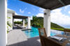 Covered dining terrace beside infinity pool with ocean and hillside views at a luxury villa rental in St Barts