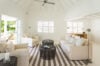 Bright living room with cream sofas, striped rug, and garden view at a private villa rental in St Barts