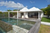 Contemporary villa with shaded terrace and stone-lined infinity pool in St Barts luxury rentals.