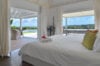 Elegant bedroom opening to terrace with infinity pool and sea view at a St Barths villa rental.