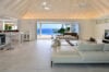 Spacious open-plan living area with ocean view and minimalist white décor at a luxury villa rental in St Barts.