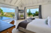 Bright bedroom with panoramic ocean views and terrace access at a luxury St Barts villa rental.