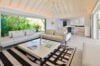 Bright open-concept living room with modern white sofas and garden views at a luxury St Barts villa rental