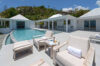Sunlit terrace with poolside loungers and panoramic ocean views at a contemporary St Barts luxury villa rental.