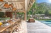 Open-air dining area at Villa Armancaya with tropical breakfast setup beside the pool and lush hillside views in St Barts