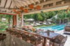 Elegant outdoor dining pavilion overlooking a long infinity pool and tropical gardens at a luxury villa rental in St Barthélemy.