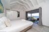 Bright bedroom with sea view and terrace access inside a contemporary St Barts villa rental.
