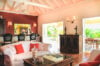 Inviting living room with coral accents, vintage furnishings, and garden view at a private villa rental in St Bart