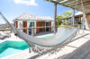 Hammock overlooking turquoise pool and sunlit terrace at a private villa rental in St Barts